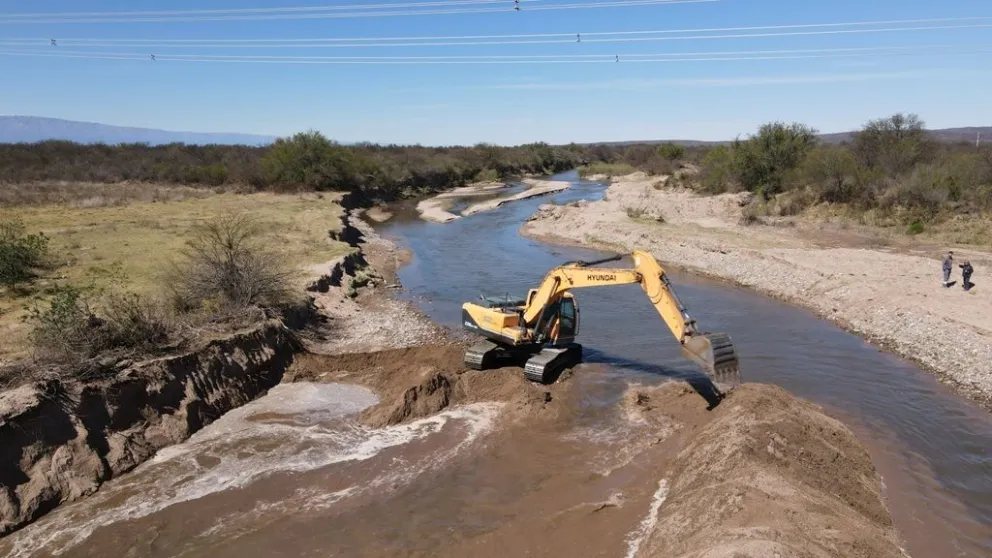 La retroexcavadora en pleno trabajo, movientos sedimentos hacia los márgenes del río.